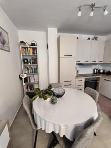 a kitchen with a white table and chairs in a room at Apartman Emily2 Dramalj in Dramalj