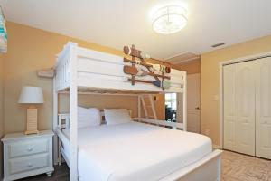 - une chambre avec des lits superposés blancs et une lampe dans l'établissement Sweet Home Apalachee by Pristine Properties Vacation Rentals, à Indian Pass