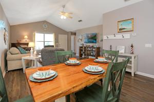 a dining room and living room with a wooden table and chairs at The Lighthouse by Pristine Properties Vacation Rentals in Saint Joe Beach +67 photos