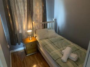 un piccolo letto con comodino e lampada di The Meadows House Cobh a Cobh