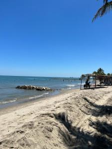 una playa con gente sentada en bancos y el océano en Manglearena, en Tolú