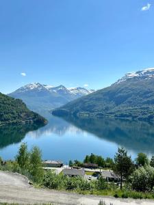 a view of a lake with snow covered mountains at Leilighet med fantastisk utsikt in Stryn