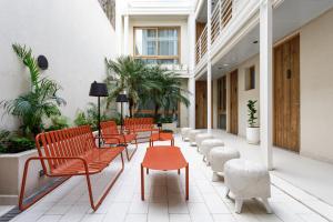 a row of chairs and a table in a courtyard at Bromelia Hotel Boutique in Buenos Aires