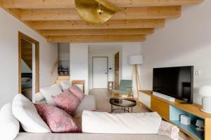 a living room with a couch and a flat screen tv at Appartement Duplex vue lac et montagne à Talloires in Talloires