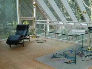 8 person holiday home in Asperup في Asperup: طاولة زجاجية وكرسي في غرفة بها نوافذ
