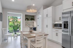 a kitchen with white cabinets and a table and chairs at Casa Del Mar- Stunning Villa with Pool and Spa in Sanibel +27 photos