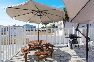 a picnic table and an umbrella on a patio at Good Day Sunshine by Pristine Properties Vacation Rentals in Mexico Beach