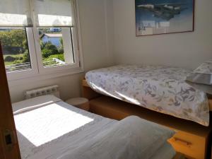 a bedroom with two beds and two windows at Apartamento Lekeitio, Garaje y WIFI in Lekeitio