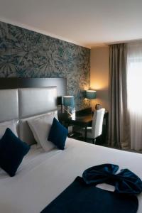 Pokój hotelowy z dużym łóżkiem i biurkiem w obiekcie Best Western Allegro Nation w Paryżu