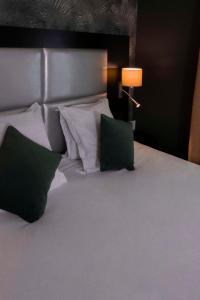 a bedroom with a bed with two pillows and a lamp at Best Western Allegro Nation in Paris