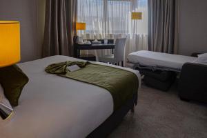 a hotel room with two beds and a desk at Best Western Allegro Nation in Paris