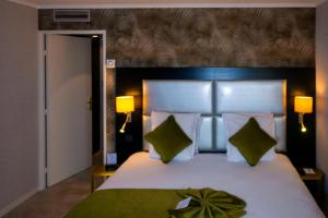 a bedroom with a large white bed with green pillows at Best Western Allegro Nation in Paris +54 photos