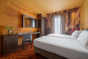 1 dormitorio con cama, escritorio y ventana en WorldHotel Casati 18, en Milán