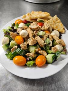 a plate of food with a salad on a table at Lewiston Hotel Bar & Grill in Lewiston