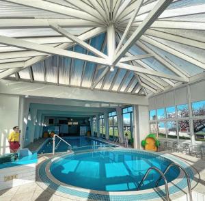 a large swimming pool in a building with a ceiling at Serene Sea Valley in Bucks Mills