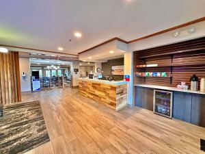 a restaurant with a bar in a room with wooden floors at SureStay Plus by Best Western Fremont I-69 in Fremont