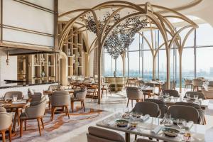 杜拜的住宿－One&Only One Za'abeel，餐厅设有桌椅和大窗户。