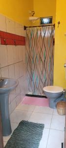 y baño con aseo y cortina de ducha. en Pousada Anjali, en Isla de Boipeba