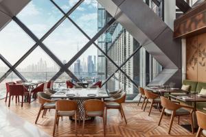 een restaurant met grote ramen en tafels en stoelen bij One&Only One Za'abeel in Dubai