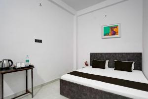 a bedroom with a large bed and a table at OYO Flagship Hotel J. S in Kānpur