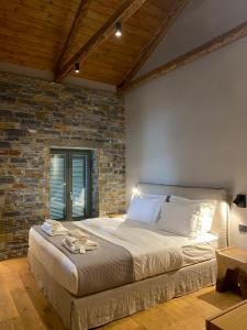 a bedroom with a large bed with a brick wall at EJ Boutique Suites in Milina