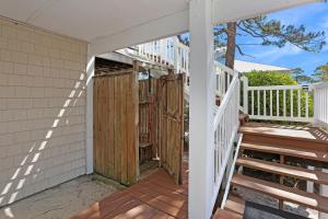 a porch with a wooden door on a house at A Swell Life by Pristine Properties Vacation Rentals in Cape San Blas +58 photos