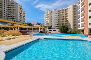 a swimming pool in the middle of two apartment buildings at Karol Vaz 4 in Portimão