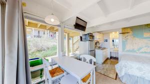 a room with a bed and a table and a kitchen at Ocean Breeze Retreat in North Truro