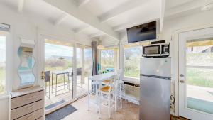 a kitchen with a refrigerator and a table at Ocean Breeze Retreat in North Truro