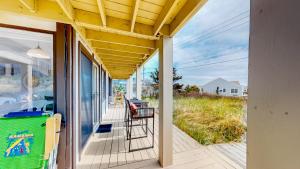 a covered porch with a view of the ocean at Ocean Breeze Retreat in North Truro