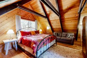 a bedroom in a log cabin with a bed and a couch at The Venado House in Arnold