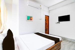 1 dormitorio blanco con 1 cama y TV en OYO RELAXING PARADISE, en kolkata