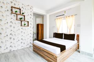 1 dormitorio con cama y pared en OYO RELAXING PARADISE, en kolkata
