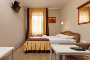 um quarto de hotel com duas camas e uma mesa em Готель Кайзер у Львові em Lviv