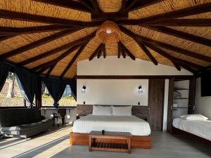 een slaapkamer met een bed en een bank bij Cabañas Villa Celeste in Villa de Leyva