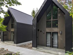 a house with black siding and windows at Summit Chalets in Hakuba