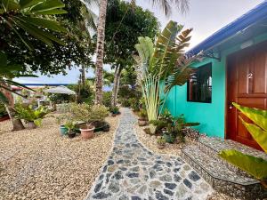 une maison avec un chemin avec des plantes devant elle dans l'établissement Bamboo Paradise Beach Resort, à Argao