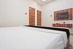 sypialnia z białym łóżkiem i telewizorem z płaskim ekranem w obiekcie OYO Black Villa w mieście Khāpri