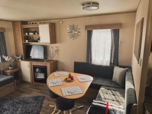 a living room with a couch and a table at 8 Berth Static Caravan in Patrington