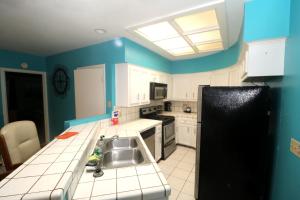 cocina con fregadero y nevera negra en The Dunes Condominiums by Cheap Getaway, en South Padre Island