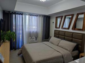 サンフェルナンドにあるSkycourt Suites at Azure North Pampanga Condominiumのベッドルーム1室(大型ベッド1台、一部の窓付)