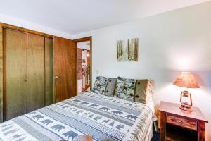 1 dormitorio con 1 cama y 1 lámpara en una mesa en New Hampshire Vacation Rental - Walk to Beach!, en Madison