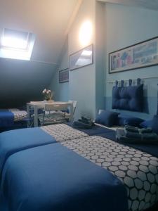 niebieski pokój z łóżkiem i kanapą w obiekcie B&B- La Casa Blu- Forum di Assago, Humanitas, Milanofiori, IEO w mieście Rozzano