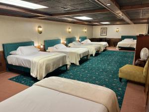 une pièce avec plusieurs lits dans une pièce dans l'établissement Fenway House Hotel, à Fennimore