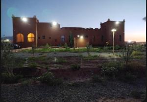a large brick building with lights on top of it at DAR AL QANASS IMANE in Midelt