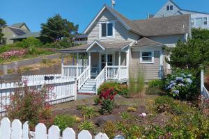 a house with a white fence in front of it at Historic Nye Creek Cottage! in Newport
