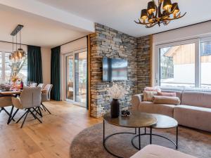 a living room with a couch and a stone wall at Mountain Chalet Luxx in Sankt Lorenzen ob Murau