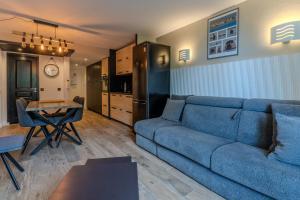 a living room with a blue couch and a table at Très bel appartement pour 5 pers au coeur du Parc équestre du Touquet in Le Touquet-Paris-Plage