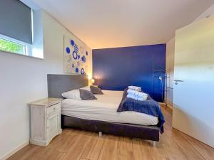 1 dormitorio con 1 cama con pared azul en Weidezicht, en Odiliapeel