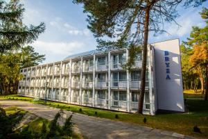 un bâtiment avec un panneau devant lui dans l'établissement Hotel *** NAT Krynica Morska, à Krynica Morska